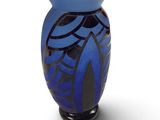 un vase bleu avec un motif sur une surface blanche