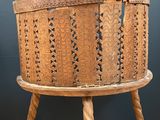 an old wooden basket sitting on top of a wooden stand