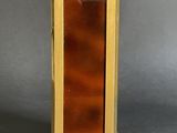 a small wooden clock on a stand on a gray surface