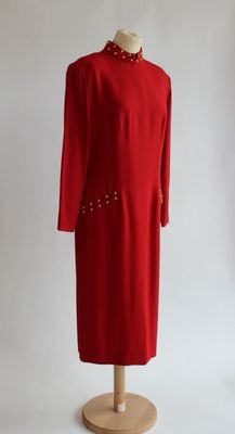 une robe rouge sur un mannequin, posée sur un fond blanc