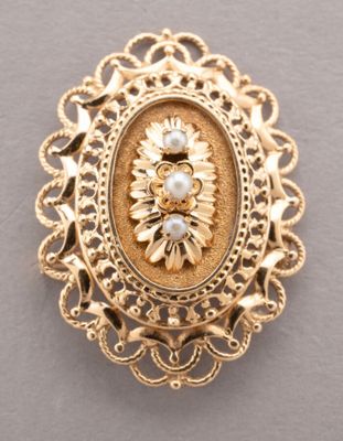 a close up of a gold broochle with pearls on it