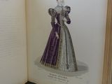 an open book with a drawing of a woman in a purple dress