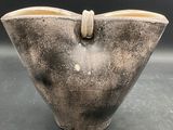 a black and white vase with a knot on the handle