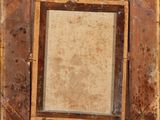 an old wooden picture frame with a picture hanging on it