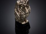 an image of a gold owl ring on a black surface