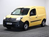 La camionnette jaune est garée dans une pièce blanche dont le sol est à carreaux.