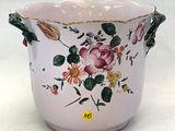 a pink vase with flowers on it on a white surface