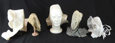 cinq chapeaux sur une tête de mannequin et un chapeau sur une tête de mannequin