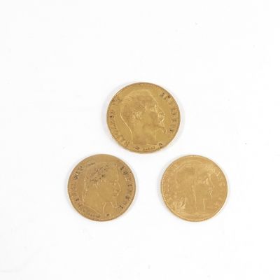 trois pièces d'or posées l'une à côté de l'autre sur une surface blanche