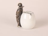 a small figurine of a man standing next to an egg