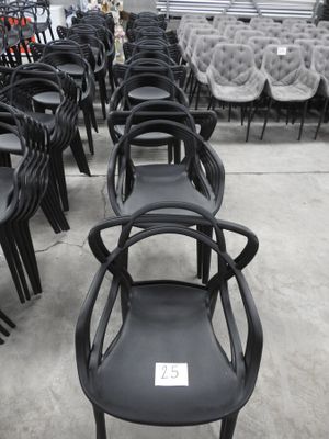 des rangées de chaises noires dans un entrepôt, avec une étiquette de prix au dos