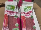 two bags of strawberries sit on top of a cardboard box