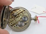 a person holding a pocket watch with a red string around it