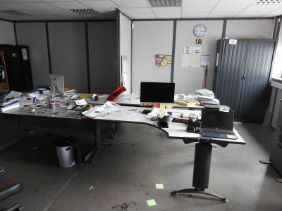 a desk that has a laptop on it in the middle of a room
