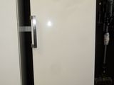 a white refrigerator that is next to a metal bowl
