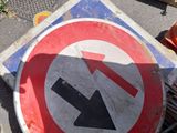 a red and white sign with an arrow on it