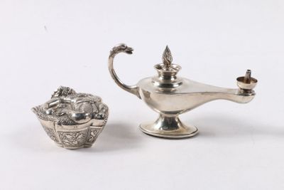 une petite théière en argent à côté d'une autre petite théière en argent