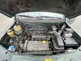 un moteur de voiture dont le capot est ouvert, garé dans la rue