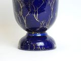 a blue vase with a gold leaf design on it