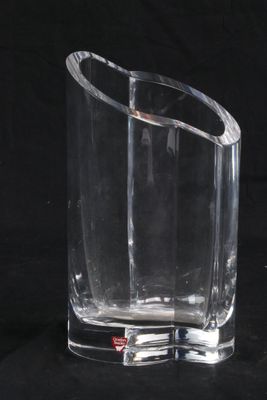 un vase en verre transparent orné d'un motif incurvé sur fond noir