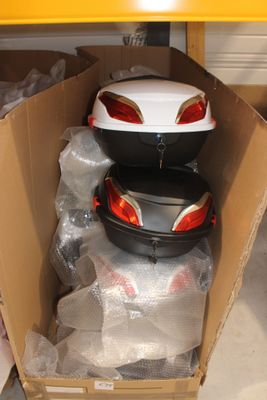une boîte posée par terre, contenant une moto