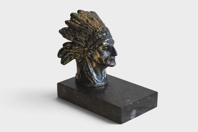 a statue of an indian head on a black marble base