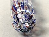 a close up of a glass pipe with a red, white and blue design on it
