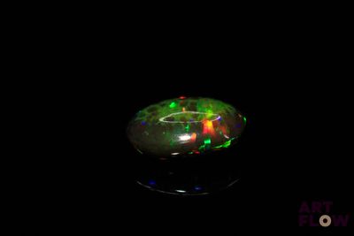 a close up of a green and red fire oplite on a black surface