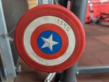 a captain america shield hanging on the side of a gym equipment rack