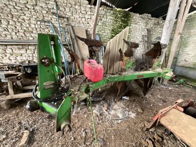 une machine verte qui est à l'arrêt dans la boue