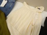 a white dress and a pair of jeans sitting on a table