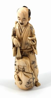statue of a man in a kimono sitting down with a dog on his lap