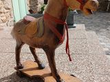 a wooden horse that is standing on a skateboard