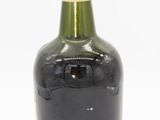 a black bottle with a yellow cap sitting on a white surface