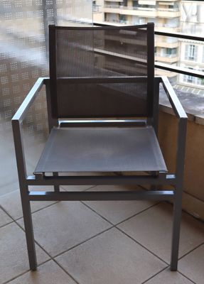 une chaise posée sur un balcon d'où l'on a vue sur la ville