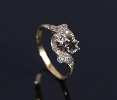 a gold and diamond ring on a black surface