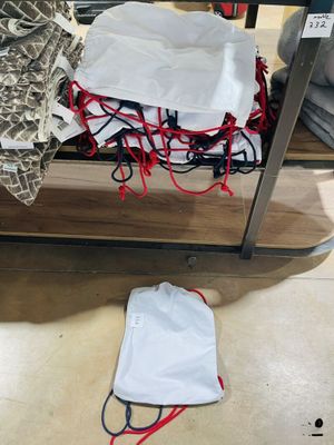 un sac blanc posé par terre à côté d'un sac posé par terre