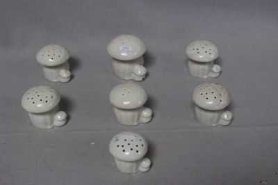 a lot of small white ceramic mushrooms on a table