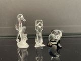 trois figurines posées sur une table en verre