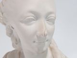 a white statue of a woman with braids on her head