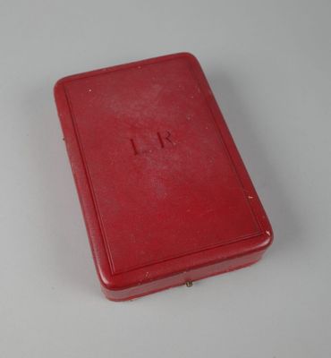une petite boîte rouge posée sur une table blanche