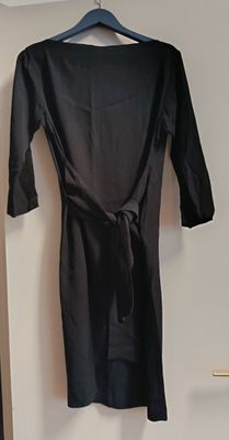 une robe noire suspendue à un cintre dans une pièce
