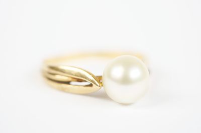 a close up of a pearl ring on a white background