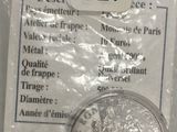 une pièce d'argent dans un sachet en plastique avec une étiquette de prix