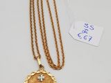 un collier en or orné d'une croix et d'une médaille