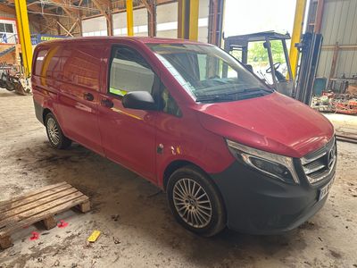 La camionnette rouge est garée dans le garage, la porte ouverte.