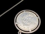 l'image d'une pièce d'argent attachée à une chaîne sur fond noir