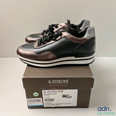 the shoe box has a pair of black and brown sneakers on it