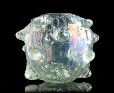 un vase en verre posé sur une surface noire