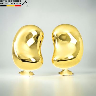deux objets dorés posés sur une surface blanche